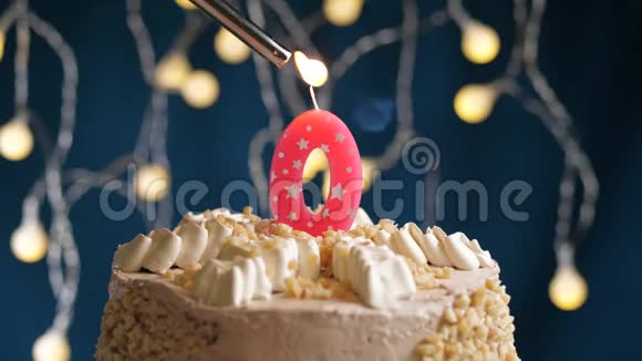 生日蛋糕0号由较轻的粉红色蜡烛燃烧在蓝色的背景上蜡烛被点燃了慢动作和特写视频的预览图
