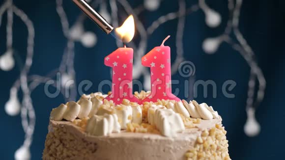 生日蛋糕11个数字燃烧由较轻的粉红色蜡烛在蓝色的背景蜡烛被点燃了慢动作视频的预览图