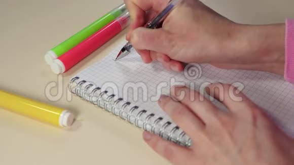 女人的特写手拿着笔在笔记本上写下愿望清单自我实现和自我的概念视频的预览图