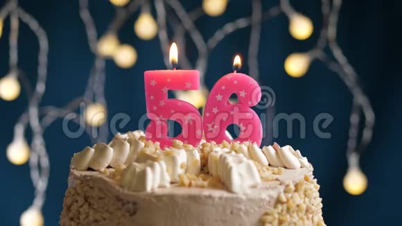 生日蛋糕上面有56个粉红色的蜡烛在蓝色的背景上燃烧蜡烛吹灭了慢速运动和特写镜头视频的预览图