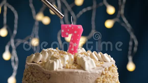 生日蛋糕7个号码燃烧由较轻的粉红色蜡烛在蓝色的背面蜡烛被点燃了慢动作和特写视频的预览图