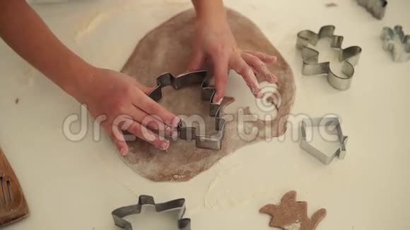 孩子的手做传统圣诞饼干的俯视图生面团和白色节日饼干的切刀视频的预览图