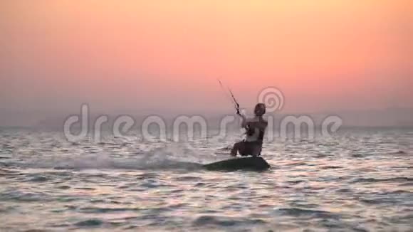 运动女风筝冲浪者在水面上滑行速度很快日落时分视频的预览图