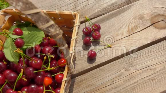 樱桃正落在装满浆果的篮子旁边的木桌上视频的预览图