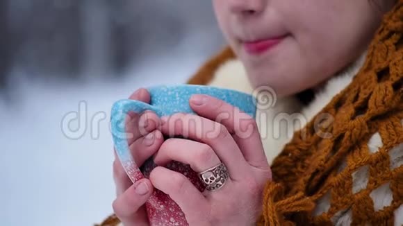 一个女人正在雪地森林里喝热茶或咖啡一个漂亮的女孩想在冬天取暖视频的预览图