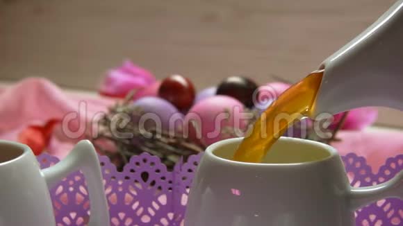 茶倒在彩粉色复活节彩蛋的背景上视频的预览图