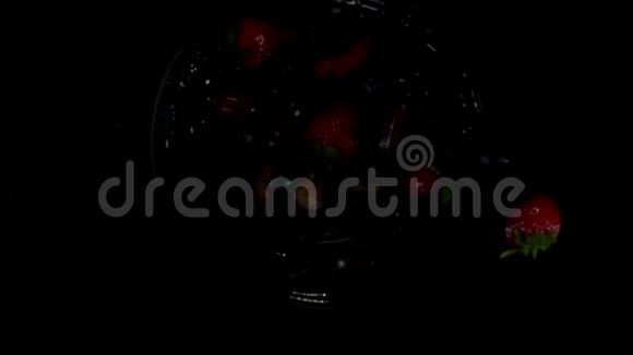 各种浆果在黑色背景上随着果汁的飞溅而飞起来视频的预览图