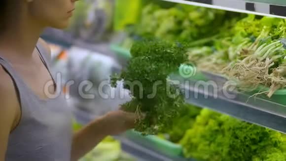 美国年轻女性在超市有机区购买绿叶蔬菜视频的预览图