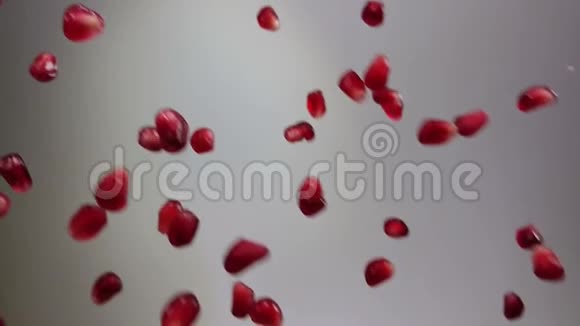 成熟石榴颗粒斜落在白色背景上视频的预览图