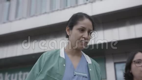 冠状病毒大流行期间瑞典医院外散步和谈话的护士特写视频的预览图