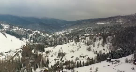 覆盖着雪景的森林山村鸟瞰图视频的预览图