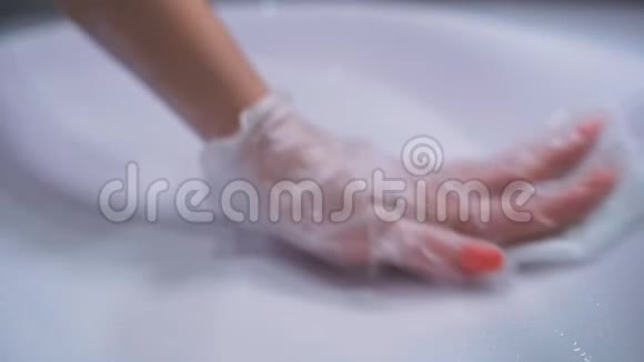 女人戴着手套手洗白色浴室洗手池每天消毒公共区域以防止扩散视频的预览图