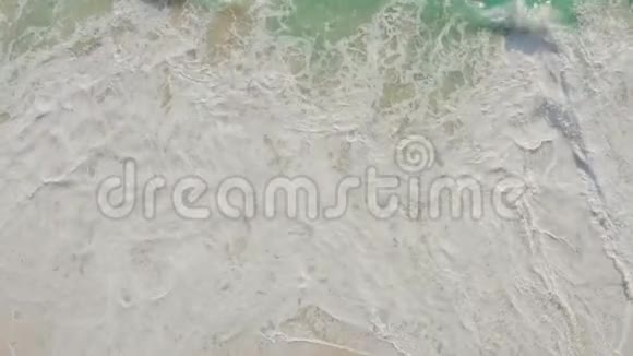 从高空俯瞰蔚蓝的海水海浪拍打在沙滩上视频的预览图