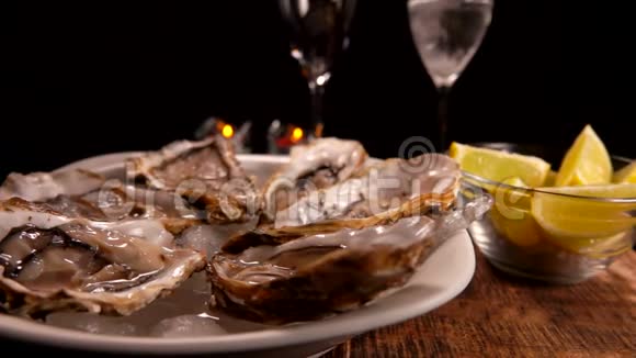 冰盘上放着新鲜的美味的牡蛎和香槟杯视频的预览图