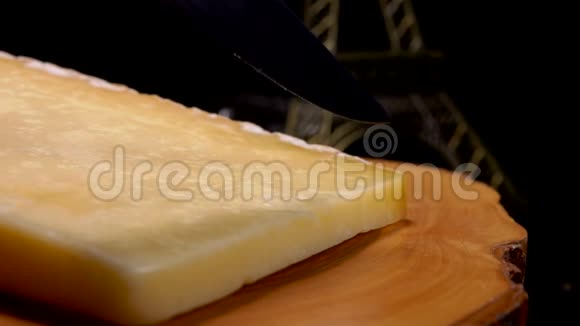 一把刀的特写是在木板上切法国硬干酪视频的预览图