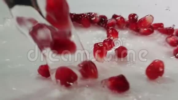水在湿漉漉的表面上流淌着多汁的红石榴粒视频的预览图