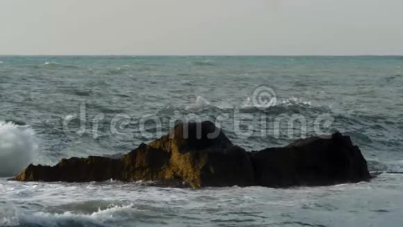 波涛汹涌的大海以强烈的飞溅击碎岩石视频的预览图