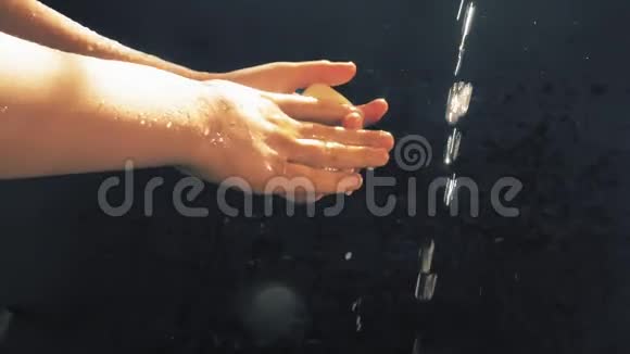 孩子们在一条小溪下的手太阳喷雾孩子洗了手视频的预览图