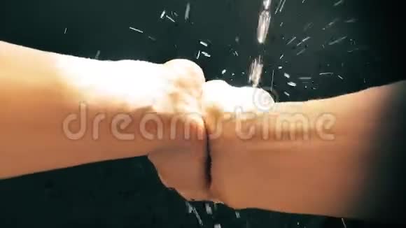 一个白人男子在水流下洗手慢速水滴喷洒视频的预览图