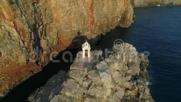黑山陡峭海岸线上岩石上白色东正教教堂的鸟瞰图视频的预览图
