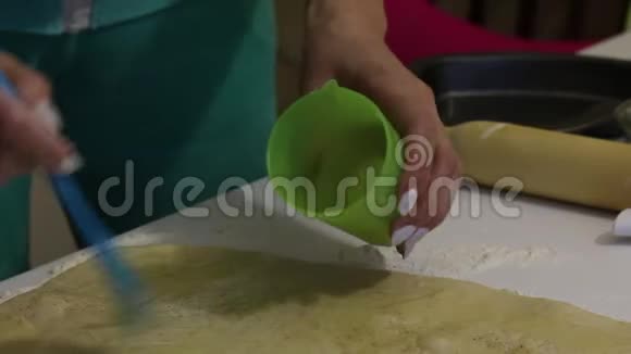 一个女人用酥油给朱砂涂上油桌子上撒满了面粉视频的预览图