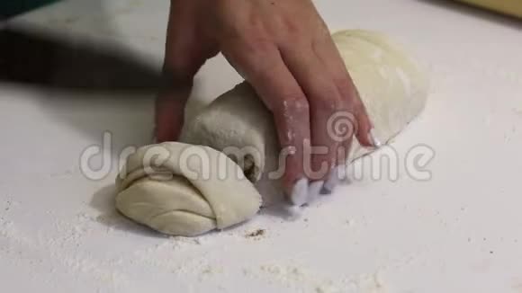 一个女人用一把刀切成一个擀面团用来做朱砂附近有烹饪工具视频的预览图