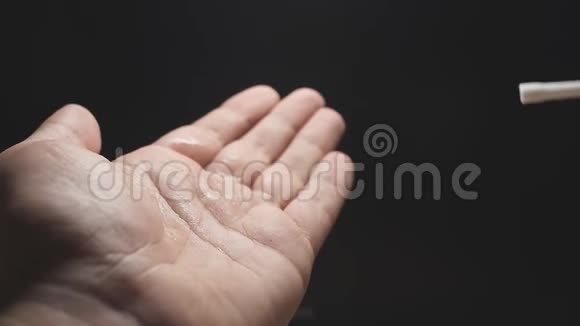 慢动作特写一个男人手中溅起的消毒剂在手掌上揉搓防止了手的扩散视频的预览图