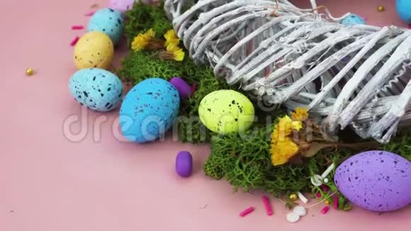 装修快乐复活节假期背景概念漂亮的粉红色书桌上的树枝和五颜六色的兔子蛋视频的预览图