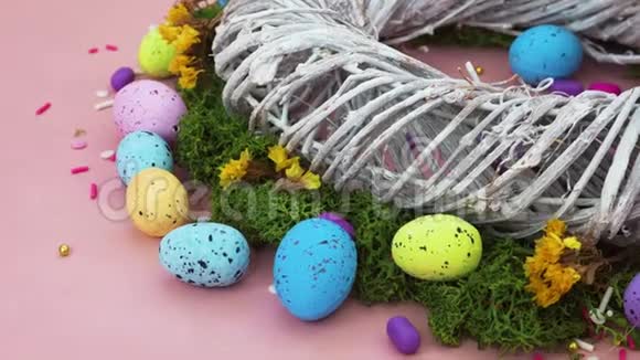 装修快乐复活节假期背景概念漂亮的粉红色书桌上的树枝和五颜六色的兔子蛋视频的预览图