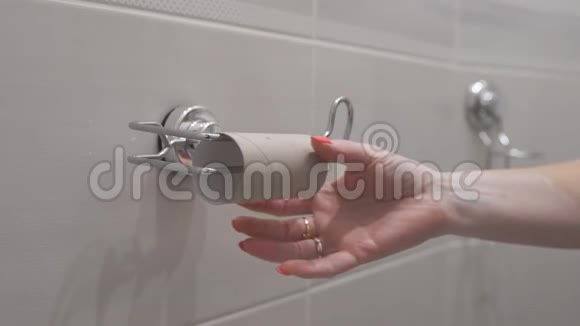 一个女人在厕所里用手换一卷卫生纸特写镜头视频的预览图