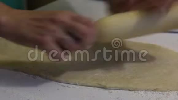 一个女人为朱砂做面团桌子上撒上面粉附近有一个烤面包的容器视频的预览图