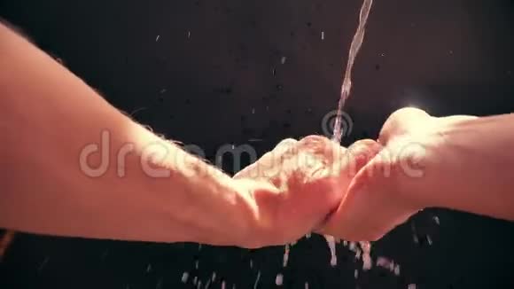 一个白人男子在水流下洗手慢速水滴喷洒视频的预览图