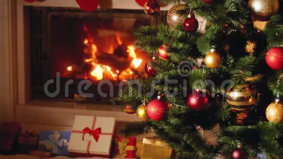 4k视频的大堆礼物和礼物旁边燃烧的壁炉和发光的圣诞树在客厅视频的预览图