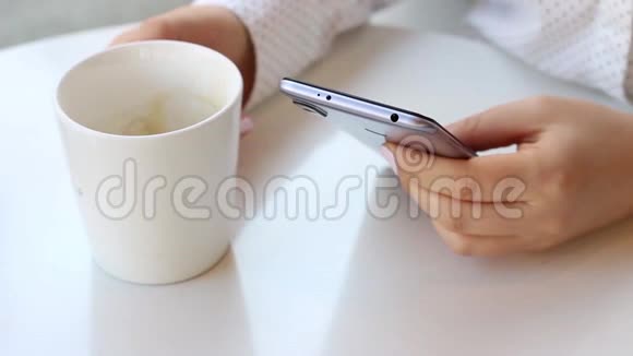女性的手正在咖啡厅的智能手机上打字视频的预览图