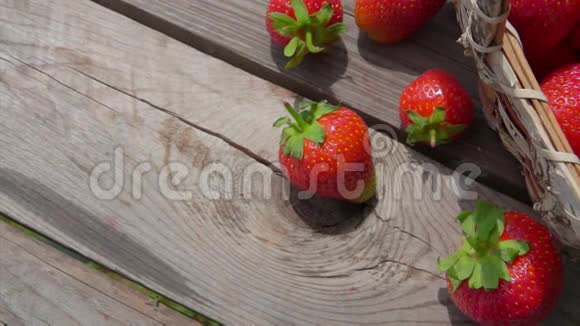 室外木制桌子上的篮子里成熟草莓的全景视频的预览图