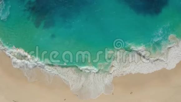 从高空俯瞰蔚蓝的海水沙滩上海浪拍打视频的预览图
