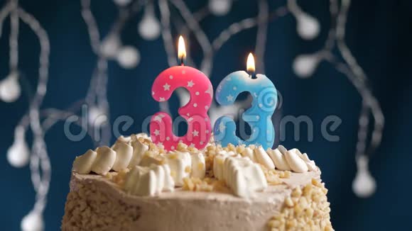 生日蛋糕蓝色背景上有33个数字的粉红色燃烧蜡烛蜡烛吹灭了慢速运动和特写镜头视频的预览图