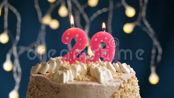 生日蛋糕蓝色背景上有29个数字的粉红色燃烧蜡烛蜡烛吹灭了慢速运动和特写镜头视频的预览图