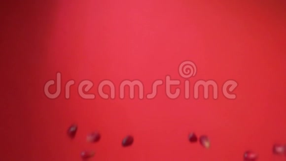 石榴粒在红色的背景上上下飞舞视频的预览图