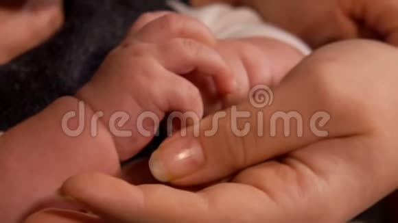 一个可爱的小宝宝的手在挤压一个成年父母的手指视频的预览图