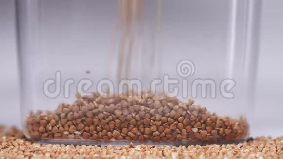 荞麦颗粒倒入罐子中储存检疫期间的有用食物冠状病毒流行视频的预览图