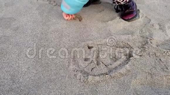 小可爱的女孩在沙滩上画笑脸家庭爱情观念视频的预览图