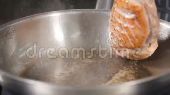 手中不可辨认的男厨翻着一块鸭肉用橄榄油在热锅里煎慢镜头视频的预览图