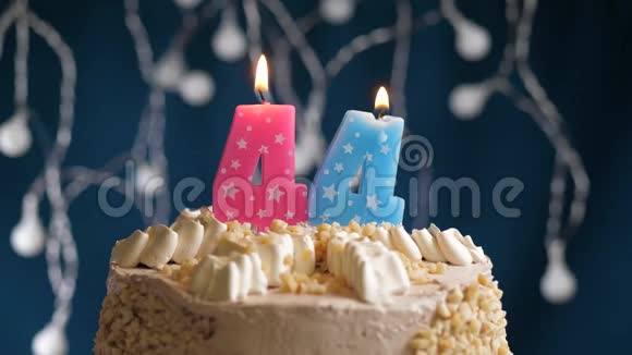生日蛋糕蓝色背景上有44个数字背景蜡烛吹灭了慢速运动和特写镜头视频的预览图