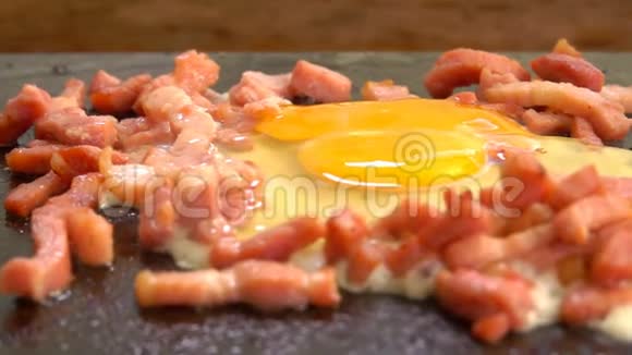 鸡蛋与切碎的培根烤在烤架的热表面视频的预览图