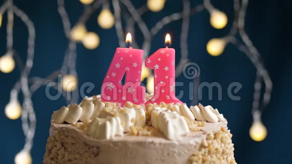 生日蛋糕41号粉红色燃烧蜡烛在蓝色背景蜡烛吹灭了慢速运动和特写镜头视频的预览图