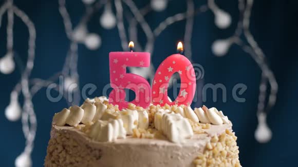 生日蛋糕蓝色背景上有50支燃烧着的粉红色蜡烛蜡烛吹灭了慢镜头和特写镜头视频的预览图