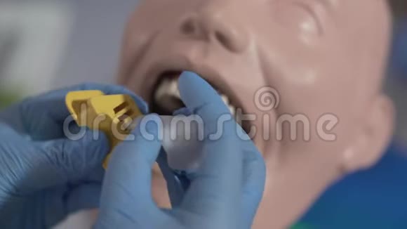 牙科人体模型口腔安装装置的极端特写无法辨认的口腔医生视频的预览图