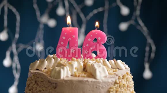 46号生日蛋糕蓝色背景的粉红色蜡烛蜡烛吹灭了慢镜头和特写镜头视频的预览图