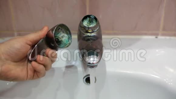 一个人手里拿着一个破裂的水龙头阀门浴室的水龙头坏了浴室的瓷砖资源保护视频的预览图